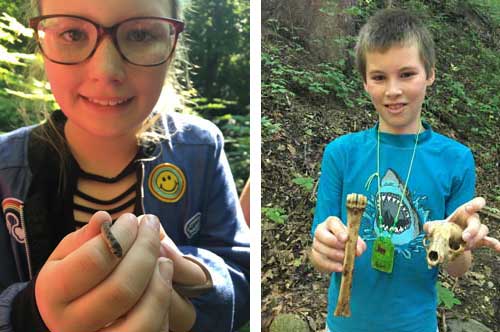 young boy holding scull and leg bone of animal and young girl holding small snake